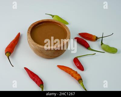 Erdnusssauce in einer kleinen Holzschüssel isoliert auf weißem Hintergrund. Stockfoto