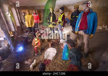 22. Dezember 2021, Rheinland-Pfalz, Ahrweiler: Mannequins in Arbeitskleidung stellen die Helfer während der Flutkatastrophe dar. Sie stehen in einem Schaufenster der Alten Stadtwache auf dem Marktplatz von Ahrweiler um die Krippe der nahegelegenen Kirche St. Laurentius. Zu Weihnachten 2021 werden zahlreiche Familien im hochwassergeschädigten Ahrtal Notunterkünfte benötigen. Bei den extremen Überschwemmungen Mitte Juli kamen hier 134 Menschen ums Leben, mehr als 750 wurden verletzt und Tausende von Häusern wurden beschädigt oder zerstört. (To dpa: Feiertage für Flutopfer im Ahrtal - Weihnachten am Wasser). Foto: Thomas Frey/dp Stockfoto