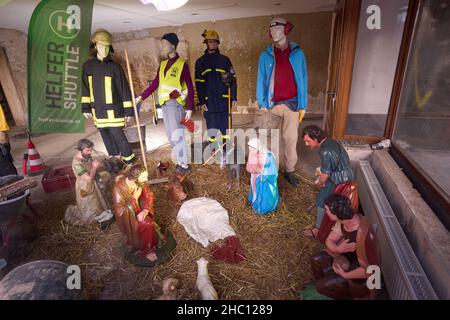22. Dezember 2021, Rheinland-Pfalz, Ahrweiler: Mannequins in Arbeitskleidung stellen die Helfer während der Flutkatastrophe dar. Sie stehen in einem Schaufenster der Alten Stadtwache auf dem Marktplatz von Ahrweiler um die Krippe der nahegelegenen Kirche St. Laurentius. Zu Weihnachten 2021 werden zahlreiche Familien im hochwassergeschädigten Ahrtal Notunterkünfte benötigen. Bei den extremen Überschwemmungen Mitte Juli kamen hier 134 Menschen ums Leben, mehr als 750 wurden verletzt und Tausende von Häusern wurden beschädigt oder zerstört. (To dpa: Feiertage für Flutopfer im Ahrtal - Weihnachten am Wasser). Foto: Thomas Frey/dp Stockfoto