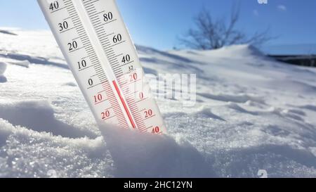 Das Thermometer liegt im Winter auf dem Schnee und zeigt niedrige negative Lufttemperatur. Meteorologische Bedingungen im rauen Klima in der nördlichen Regi Stockfoto