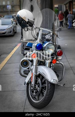 San Francisco, USA - 18. Dezember 2021: Polizeispezial Harley Davidson Cruiser Motorrad mit einem Motoroffizier Helm auf dem Union Square geparkt Stockfoto