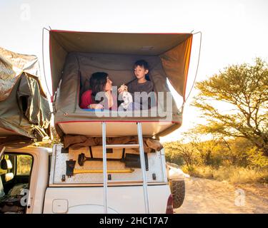 Mutter und Sohn in einem Dachzelt in Afrika Stockfoto