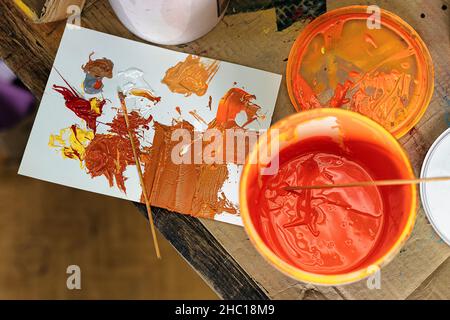 Rote, orange und gelbe Plastisoltinte (Farbe) Nahaufnahme. Siebdruck-Produktion. T-Shirts im Siebdruck-Verfahren in einem Designstudio drucken Stockfoto