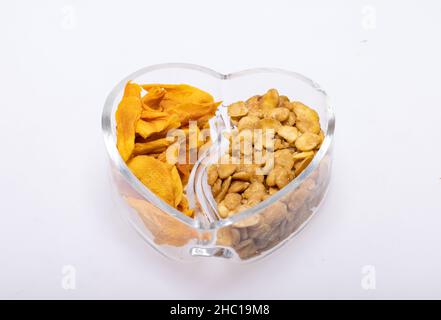 Geröstete und gesalzene Fava-Bohnen und getrocknete Mangoscheiben für einen gesunden veganen und vegetarischen Ernährungs-Snack. Reich an Eiweiß, Vitaminen, Ballaststoffen und Nutri Stockfoto