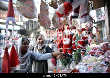 Jammu, das von Indien kontrollierte Kaschmir. 18th Dez 2021. Mädchen kaufen Dekorationsartikel für das Weihnachtsfest in Jammu, der Winterhauptstadt des von Indien kontrollierten Kaschmir, am 18. Dezember 2021. Quelle: Str/Xinhua/Alamy Live News Stockfoto