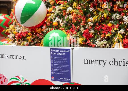 Gesundheitsberatung in Sydney Schützen Sie sich neben dem öffentlichen Weihnachtsbaum im Martin Place vor Viren, wie omicron-Fälle es fordern, Sydney, Australien Stockfoto