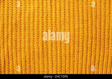 Orangefarbener, warmer Pullover mit gestreiftem, minimalistischem Hintergrund. Stockfoto