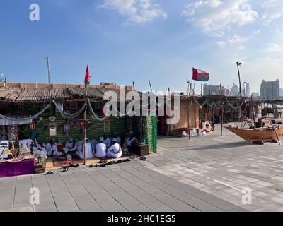 Gruppe traditioneller arabischer Fischer, die im Katara-Kulturdorf in Doha, Katar, während des elften traditionellen Dhow-Festivals in Katara, Tageslichtansicht sitzen Stockfoto