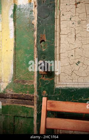 Verwitterte Innentür mit Stuhlrücken Stockfoto