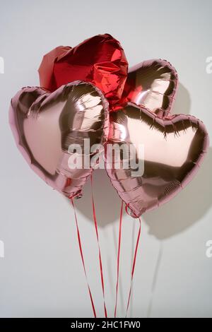 Ein Satz herzförmiger Liebeszeichen. Ein Geschenk, um die Liebe zum Anderen zu zeigen. Pinke Heliumballons. Stockfoto