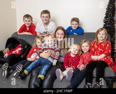 Jennifer Johnston mit neun ihrer vierzehn Kinder, sieben Wochen alt Freya, Jaxon, 22 Monate, Ebony, drei, Heidi, vier, Sofia, sechs, Lydia, Acht, Alfie, neun, Joell, 12, Und Kaleb, 14, in ihrem Haus in Newry, in Co Down. Jennifer Johnston, 42, hat vor kurzem ihr 14th-jähriges Kind zur Welt gebracht und erzählte der Nachrichtenagentur PA von dem festlichen Spaß, das Weihnachtsessen für eine der größten Familien in Großbritannien zu kochen. Bilddatum: Montag, 13. Dezember 2021. Stockfoto