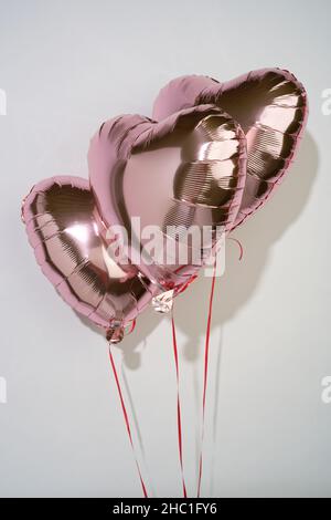 Ein Satz herzförmiger Liebeszeichen. Ein Geschenk, um die Liebe zum Anderen zu zeigen. Pinke Heliumballons. Stockfoto