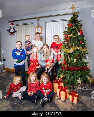 Jennifer Johnston mit neun ihrer vierzehn Kinder, sieben Wochen alt Freya, Jaxon, 22 Monate, Ebony, drei, Heidi, vier, Sofia, sechs, Lydia, Acht, Alfie, neun, Joell, 12, Und Kaleb, 14, in ihrem Haus in Newry, in Co Down. Jennifer Johnston, 42, hat vor kurzem ihr 14th-jähriges Kind zur Welt gebracht und erzählte der Nachrichtenagentur PA von dem festlichen Spaß, das Weihnachtsessen für eine der größten Familien in Großbritannien zu kochen. Bilddatum: Montag, 13. Dezember 2021. Stockfoto