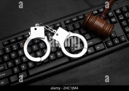 Richter Gavel und Polizei Handschellen auf Computer-Tastatur. Konzept der Cyberkriminalität. Online-Piratentum Stockfoto