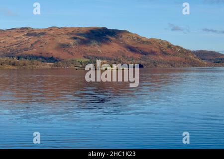 Blick auf den See von Ullswater in Cumbria The Lake District Nation Park. Morgenlicht, Blick fällt mit einem leichten Nebel. Blaue Reflexe. Stockfoto