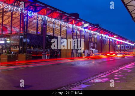 Weihnachtslichter bei Nacht auf dem überdachten Marktgebäude in Preston, Lancashire. Dezember 2021. Hochwertige, große festliche Beleuchtung, beleuchtete, festgedeckte Markthalle im Innenbereich mit einem großen viktorianischen Vordach, Ein Glashaus lässt Licht in allen Winkeln in Earl Street, Preston, Lancashire, England. Es ist ein denkmalgeschütztes Gebäude, erbaut 1870-75, das heute moderne und zeitgenössische Einkaufsmöglichkeiten bietet. Stockfoto