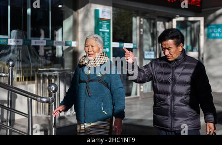 (211217) -- LHASA, 17. Dezember 2021 (Xinhua) -- Dawa Lhadron (L) und ein Freund gehen auf einer Straße in Lhasa, südwestlich der Autonomen Region Tibet, am 7. Dezember 2021. Dawa Lhadron, geboren 1945, lebt heute in Lhasa ein glückliches Leben. Es erscheint ihr jedoch wie ein Alptraum, auf das zurückzublicken, was sie als Leibeigene in ihrer Kindheit erlitten hatte. „der größte gefährliche Faktor für mich, Schafe für Leibeigene zu hüten, waren diese Adler, da sie dazu neigen, in den Himmel zu tauchen und die Lämmer wegzutragen“, sagte Dawa. Um sich gut um die Schafe zu kümmern, musste sie aus Angst vor möglichen Aggressionen von Adlern den Himmel im Auge behalten. Stockfoto