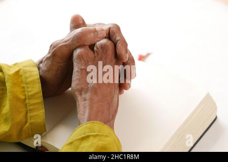 Ältere Frauen halten eine bibel in den Händen und beten. Stockfoto