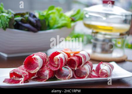 Geschnittene rohe Rinderrollen für heißen Topf auf weißem Teller Stockfoto