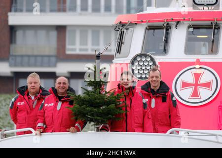 Cuxhaven, Deutschland. 23rd Dez 2021. Die Besatzung des Seerettungskreuzers 'Hans Hackmack' - von links Leif Rohwer (3rd Vorarbeiter), Klaus Bens (ehrenamtlicher Helfer), Vorarbeiter Ulf Pirwitz und Maschinist Thorsten Müller stehen auf ihrem Schiff in Cuxhaven. Nicht jeder feiert Weihnachten mit seiner Familie unter dem Weihnachtsbaum: Der Deutsche Seerunddienst (DGzRS) ist immer einsatzbereit. Quelle: Markus Hibbeler/dpa/Alamy Live News Stockfoto