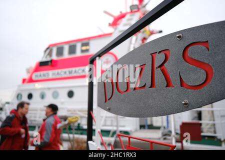 Cuxhaven, Deutschland. 23rd Dez 2021. Mitglieder der Besatzung des Seerettungskreuzers 'Hans Hackmack' plaudern vor dem Schiff. Nicht jeder feiert Weihnachten mit seiner Familie unter dem Weihnachtsbaum: Der Deutsche Seerunddienst (DGzRS) ist immer einsatzbereit. Quelle: Markus Hibbeler/dpa/Alamy Live News Stockfoto