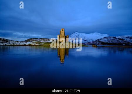 Das Ardvreck Castle aus dem 16th. Jahrhundert am Loch Assynt in Sutherland, Schottland, wurde nach Sonnenuntergang künstlich beleuchtet. Stockfoto