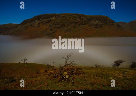 Ein Mondnebel, der während eines Vollmonds über Wasdale Head in Cumbria bei einer Temperaturinversion gefangen wurde. Stockfoto