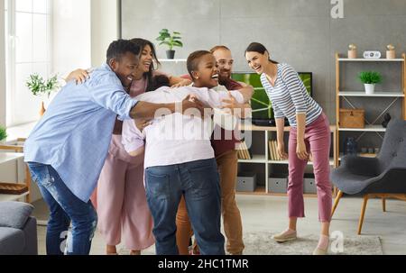 Gruppe von glücklich aufgeregt jungen multirassischen Freunden Spaß haben und umarmen sich gegenseitig Stockfoto