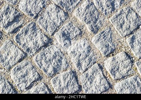 Hintergrundtextur aus Mauerwerk mit Sand in Nähten zwischen Pflastersteinen. Kreisförmige Linien, Draufsicht. Stockfoto