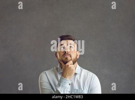 Der Mann, der über Zweifel dachte, konzentrierte sich mit dem Finger auf dem Kinn und wunderte sich Stockfoto