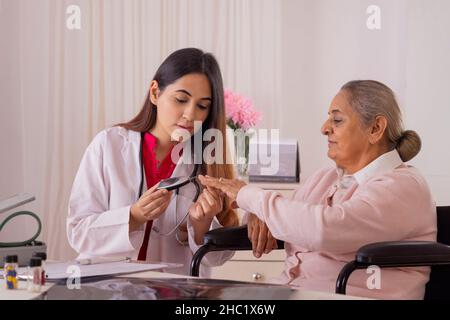 Ärztin, die den Blutzucker einer älteren Frau untersucht Stockfoto