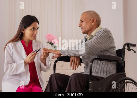 Krankenschwester, die den Blutzucker eines alten Mannes überprüft Stockfoto