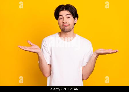 Portrait von attraktiven ahnungslos braunhaarigen Kerl zuckende Schultern isoliert über hellen gelben Hintergrund Stockfoto