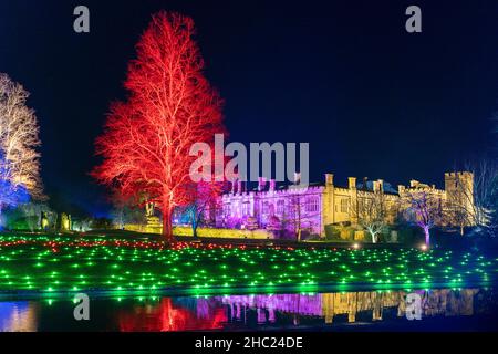 Winchcombe, Großbritannien. 22. Dezember 2021. Die Gebäude und das Gelände von Schloss Sudeley leuchten während des diesjährigen Spektakels „Spectacle of Light“ mit Farbe. Das mittlerweile sechste Jahr nach Einbruch der Dunkelheit umfasst einen beleuchteten Pfad rund um das Gelände und den Wald von Sudeley, glitzernde Wasserspielen und einen einzigartigen „Teppich aus Farbe“. Quelle: Carl Hewlett/Alamy Live News Stockfoto