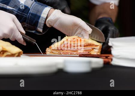 Francesinha, traditionelles portugiesisches Sandwich, ursprünglich aus Porto. Konzept der nationalen Küche. Der Küchenchef bereitet ein Gericht im Restaurant zu Stockfoto