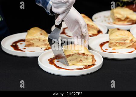Francesinha, traditionelles portugiesisches Sandwich, ursprünglich aus Porto. Konzept der nationalen Küche. Der Küchenchef bereitet ein Gericht im Restaurant zu Stockfoto