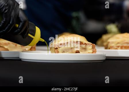 Francesinha, traditionelles portugiesisches Sandwich, ursprünglich aus Porto. Konzept der nationalen Küche. Der Küchenchef bereitet ein Gericht im Restaurant zu Stockfoto