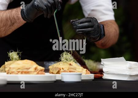 Francesinha, traditionelles portugiesisches Sandwich, ursprünglich aus Porto. Konzept der nationalen Küche. Der Küchenchef bereitet ein Gericht im Restaurant zu Stockfoto