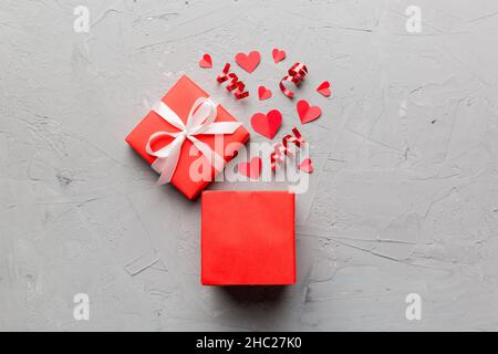 Happy Valentinstag geöffnete herzförmige Geschenkbox mit kleinen Herzen, auf farbigem Hintergrund, Valentinskarte - Draufsicht Konzept. Stockfoto
