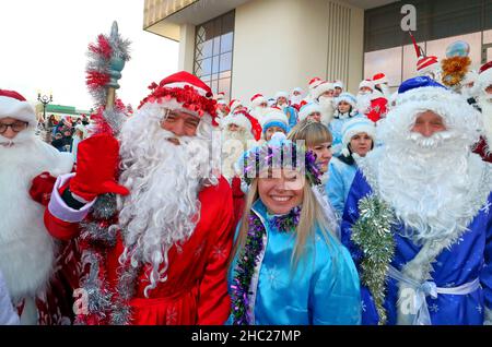 (211220) -- MINSK, 20. Dezember 2021 (Xinhua) -- in den Kostümen von Pater Frost und Snow Maiden gekleidete Menschen nehmen am 19. Dezember 2021 an einer Neujahrsparade in Minsk, Weißrussland, Teil. (Foto von Henadz Zhinkov/Xinhua) Stockfoto