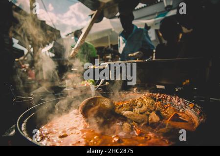 Cheff serviert internationale Fusionskusine am Straßenstand auf dem internationalen Street Food Festival von Odprta kuhna, Open Kitchen Event, in Ljubljana Stockfoto