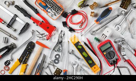 Set von Handwerkzeugen auf weißem Gips Hintergrund. Arbeitswerkzeuge für Elektriker, Tischler, Mechaniker, Installateur und Hobiker. Draufsicht, flach liegend. Stockfoto