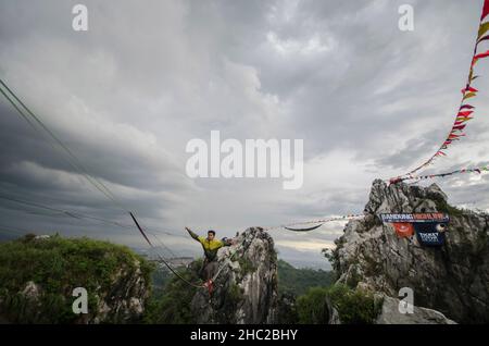 Bandung, West-Java. 18th Dez 2021. Ein Teilnehmer wagt sich am Seil während des Bandung Highline Festivals 2021 in Bandung, West Java, Indonesien. 18. Dezember 2021. Quelle: Septianjar/Xinhua/Alamy Live News Stockfoto