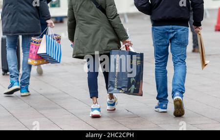 Hamburg, Deutschland. 23rd Dez 2021. Passanten laufen am Tag vor Weihnachten mit Einkaufstaschen durch die Innenstadt. Quelle: Markus Scholz/dpa/Alamy Live News Stockfoto