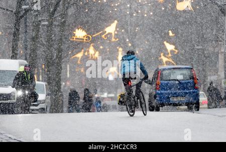 Hamburg, Deutschland. 23rd Dez 2021. Am Nachmittag driftet leichter Schnee in der Innenstadt an der Mönckebergstraße. Quelle: Markus Scholz/dpa/Alamy Live News Stockfoto