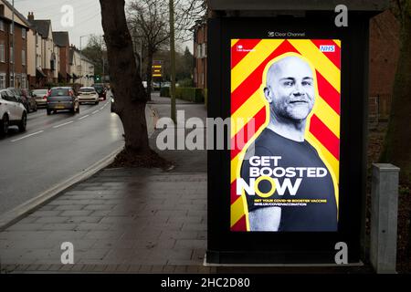 Beleuchtetes „Get Boosted Now“-Poster auf einer Busstation, Warwick, Großbritannien. Dezember 2021. Stockfoto
