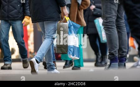 Hamburg, Deutschland. 23rd Dez 2021. Passanten laufen am Tag vor Weihnachten mit Einkaufstaschen durch die Innenstadt. Quelle: Markus Scholz/dpa/Alamy Live News Stockfoto