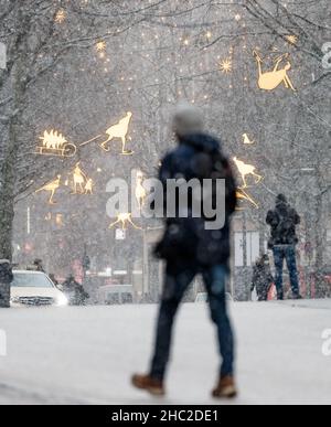 Hamburg, Deutschland. 23rd Dez 2021. Am Nachmittag driftet leichter Schnee in der Innenstadt an der Mönckebergstraße. Quelle: Markus Scholz/dpa/Alamy Live News Stockfoto