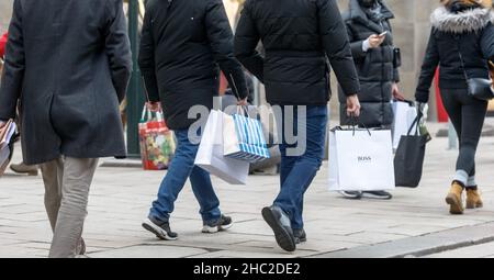 Hamburg, Deutschland. 23rd Dez 2021. Passanten laufen am Tag vor Weihnachten mit Einkaufstaschen durch die Innenstadt. Quelle: Markus Scholz/dpa/Alamy Live News Stockfoto
