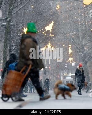 Hamburg, Deutschland. 23rd Dez 2021. Am Nachmittag driftet leichter Schnee in der Innenstadt an der Mönckebergstraße. Quelle: Markus Scholz/dpa/Alamy Live News Stockfoto